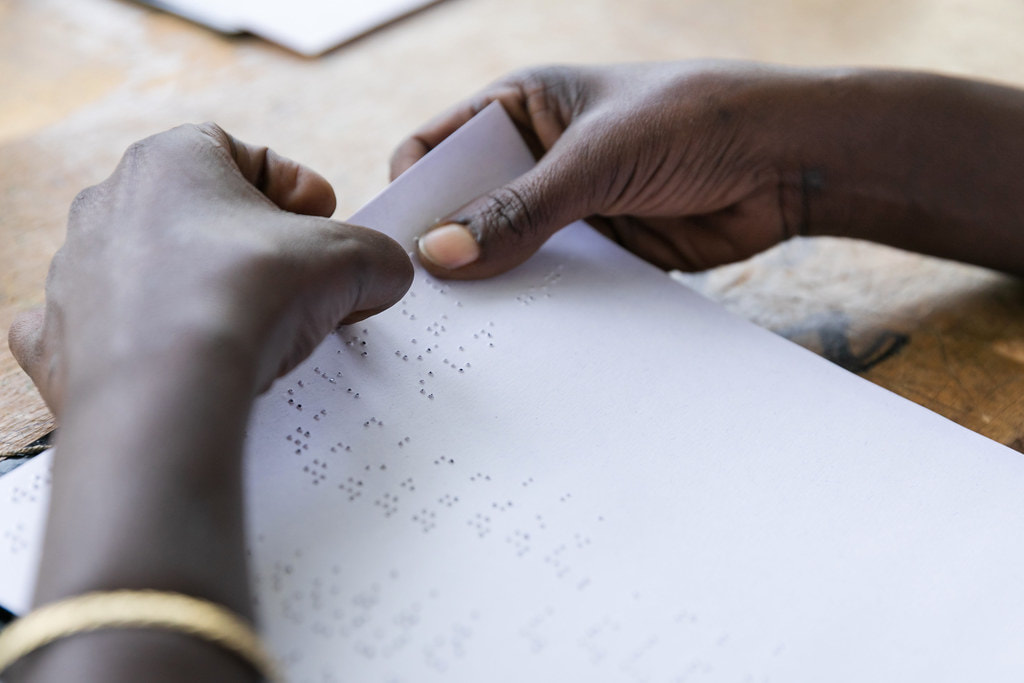 A person reading via braille. Image shows the page and person's hands