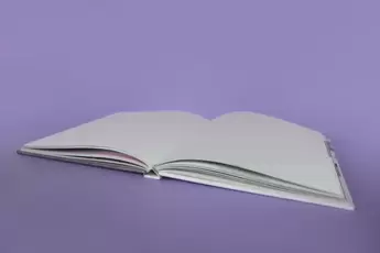 An open, empty book on a grey background